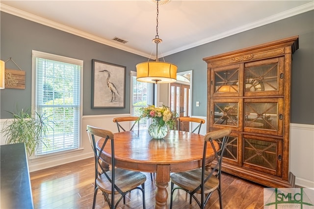 dining area featuring crown molding and hardwood / wood-style flooring