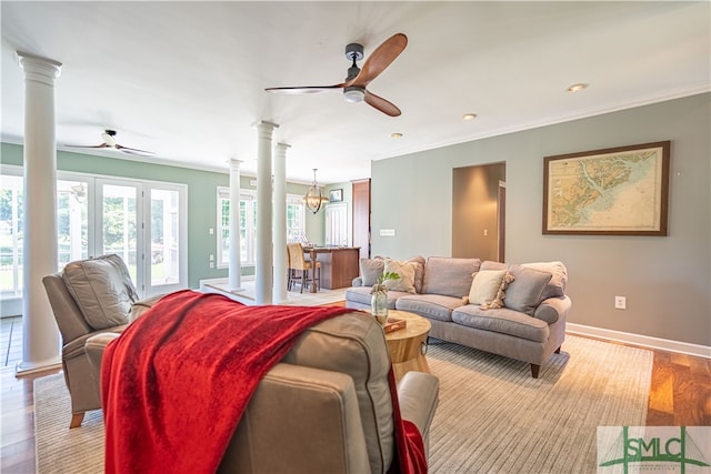 living room featuring ceiling fan with notable chandelier, light hardwood / wood-style floors, and ornate columns