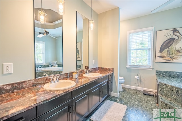 bathroom featuring vanity, toilet, ceiling fan, and a healthy amount of sunlight