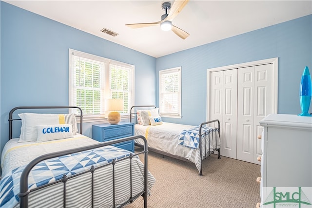 carpeted bedroom with ceiling fan and a closet