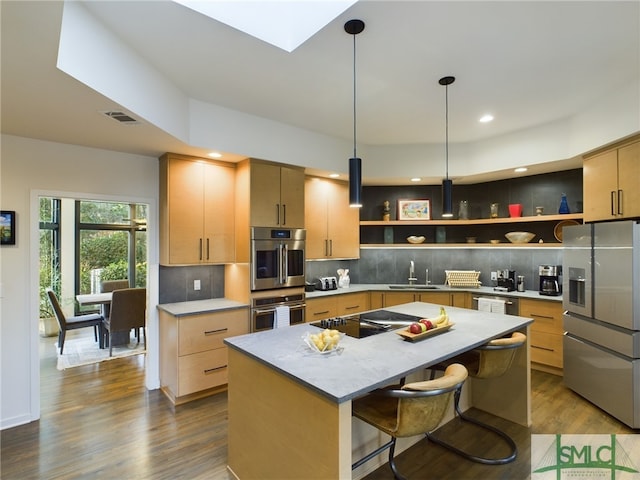 kitchen with stainless steel appliances, sink, a center island, and light brown cabinets