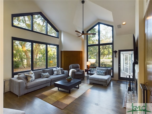 living room featuring dark wood-type flooring, ceiling fan, and high vaulted ceiling