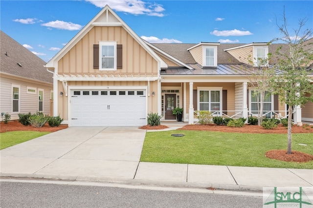 view of front of house featuring a front lawn, a garage, and a porch