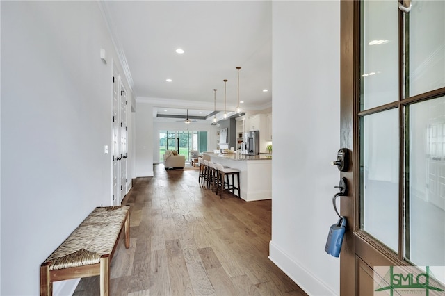 foyer featuring hardwood / wood-style floors and crown molding