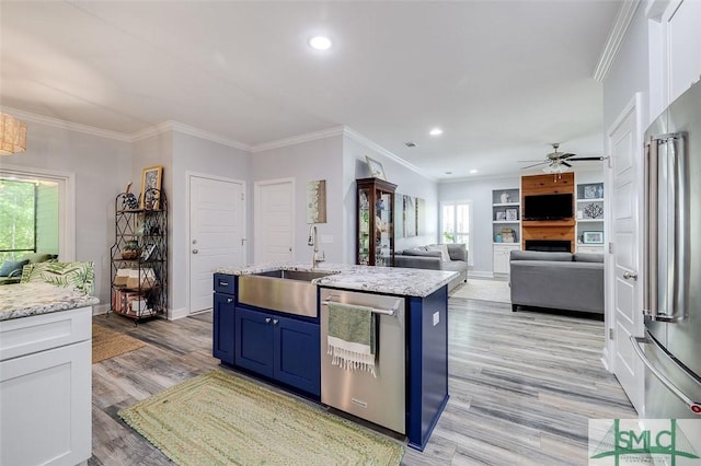 kitchen with white cabinets, sink, stainless steel appliances, and a kitchen island with sink