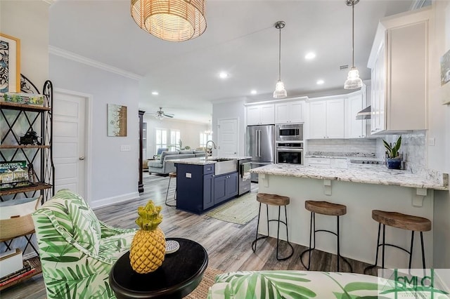 kitchen featuring a center island, backsplash, blue cabinetry, appliances with stainless steel finishes, and white cabinetry