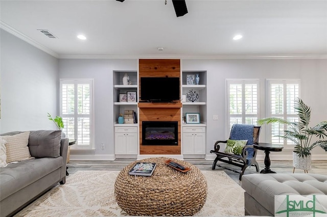 living room featuring light hardwood / wood-style floors, plenty of natural light, and ornamental molding