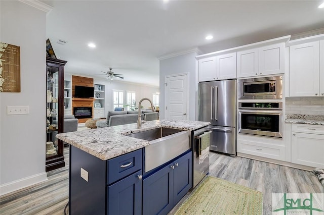 kitchen featuring ceiling fan, sink, white cabinets, and stainless steel appliances