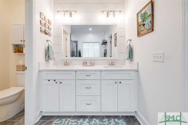 bathroom with vanity, toilet, a shower with door, and ornamental molding