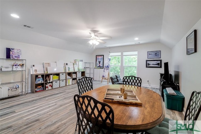 dining room featuring light hardwood / wood-style flooring, vaulted ceiling, and ceiling fan