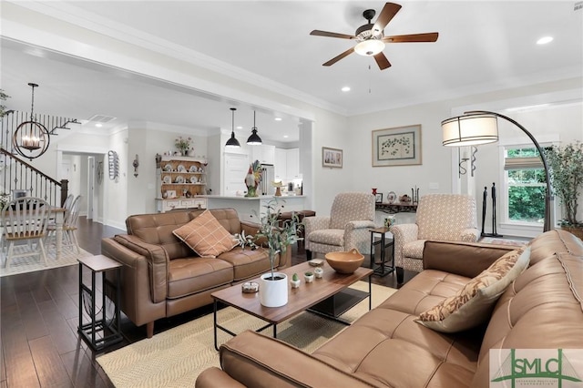 living room with crown molding, dark wood-type flooring, and ceiling fan with notable chandelier