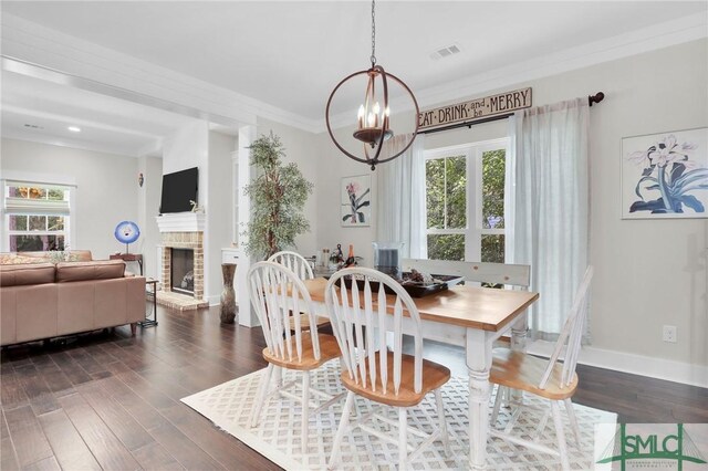 dining area featuring ornamental molding, dark hardwood / wood-style floors, a brick fireplace, and a notable chandelier