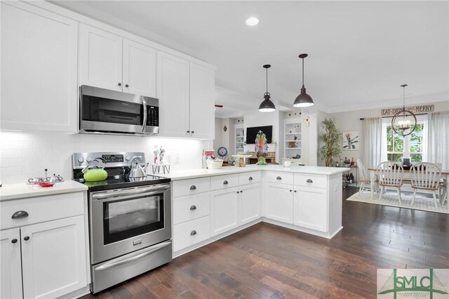 kitchen with kitchen peninsula, pendant lighting, stainless steel appliances, and dark wood-type flooring