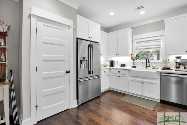 kitchen with dark hardwood / wood-style flooring, white cabinetry, sink, and appliances with stainless steel finishes