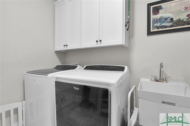 laundry area featuring cabinets, washer and clothes dryer, and sink