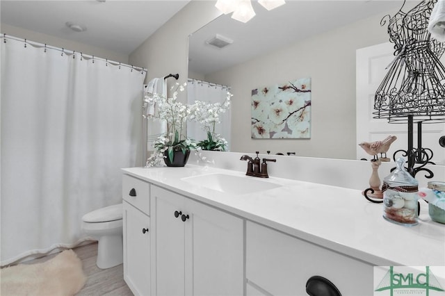 bathroom featuring hardwood / wood-style floors, vanity, and toilet