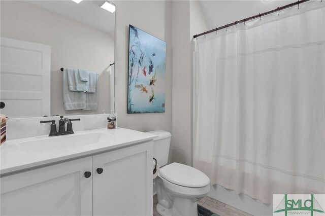 full bathroom with shower / tub combo with curtain, vanity, and toilet