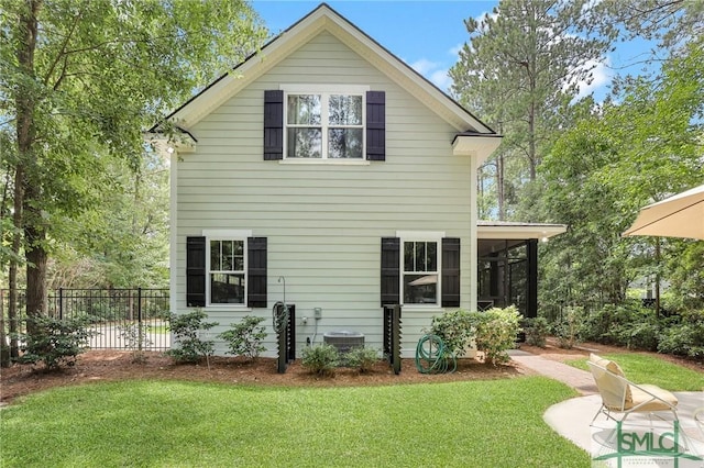 back of house with a yard, central AC unit, and a sunroom