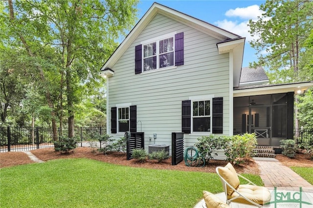 rear view of property with a yard, a sunroom, and central air condition unit