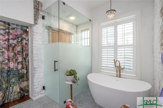 bathroom with separate shower and tub and a notable chandelier