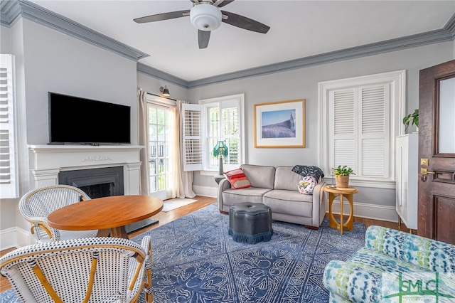 living room with hardwood / wood-style floors, ceiling fan, and crown molding