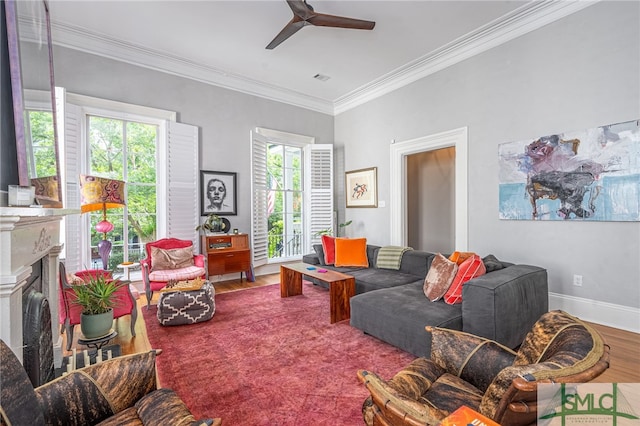 living room with a wealth of natural light, crown molding, ceiling fan, and wood-type flooring