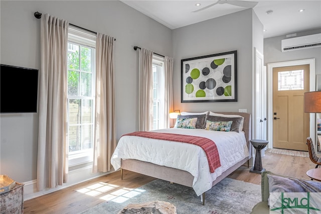 bedroom featuring a wall mounted air conditioner and wood-type flooring