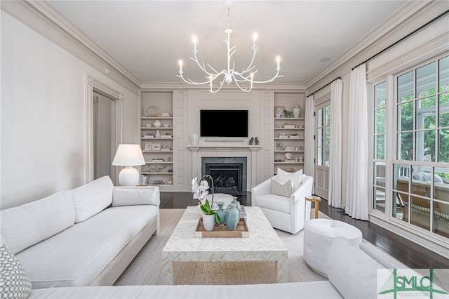 living room with crown molding, built in features, hardwood / wood-style floors, and an inviting chandelier