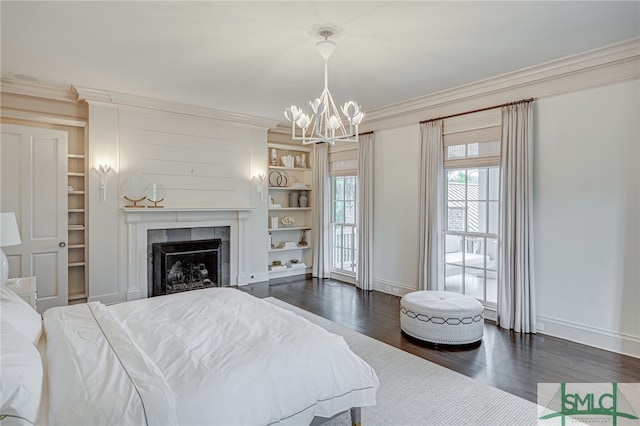 bedroom with a tile fireplace, dark hardwood / wood-style floors, a chandelier, and ornamental molding