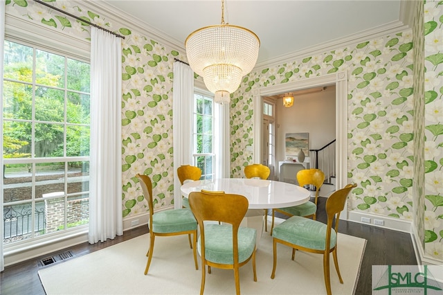 dining room with a chandelier, dark hardwood / wood-style floors, plenty of natural light, and crown molding