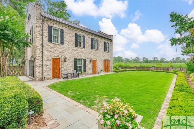 view of front facade featuring a patio area and a front lawn