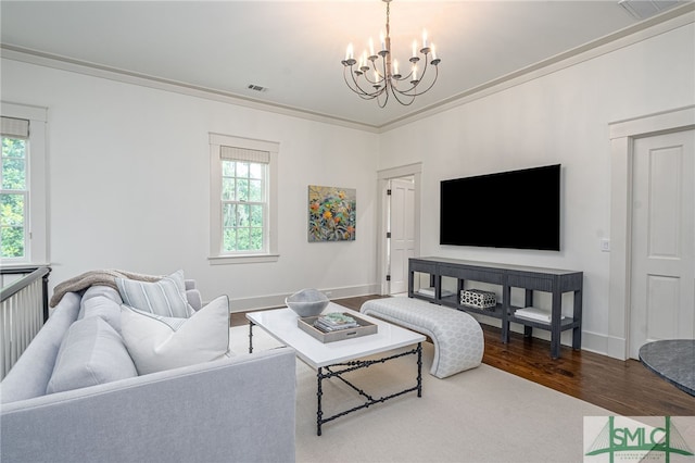 living room featuring hardwood / wood-style floors, ornamental molding, and a chandelier