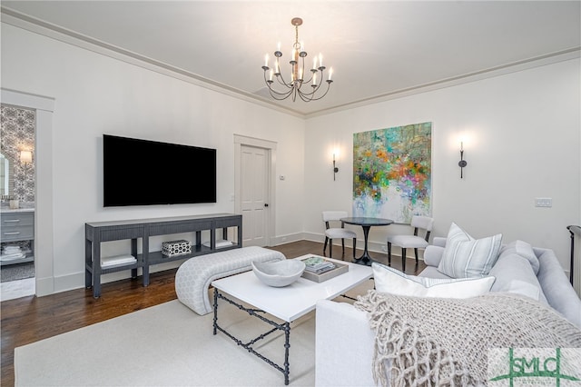 living room featuring dark hardwood / wood-style flooring, ornamental molding, and a notable chandelier