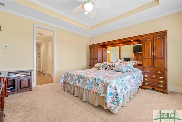 bedroom with crown molding, light colored carpet, and a raised ceiling