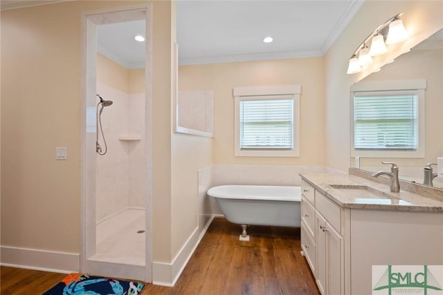 bathroom featuring ornamental molding, wood-type flooring, separate shower and tub, and vanity