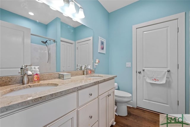 bathroom with vanity, hardwood / wood-style floors, toilet, and a shower