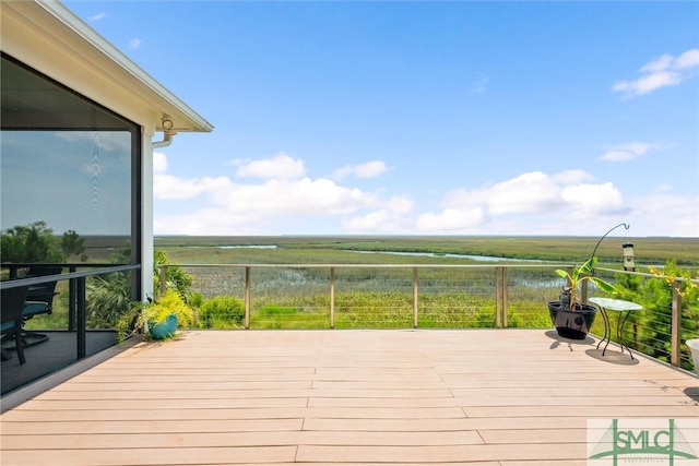 wooden terrace with a rural view and a water view