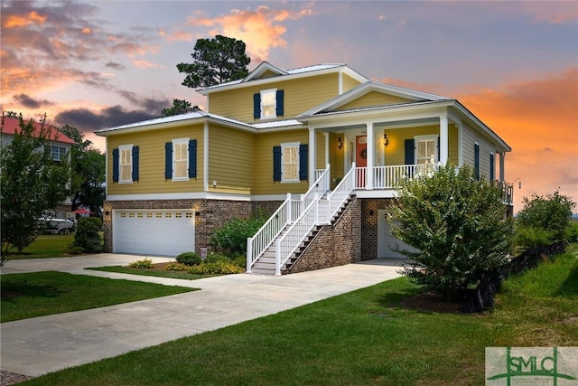 view of front of house featuring a garage, a yard, and covered porch