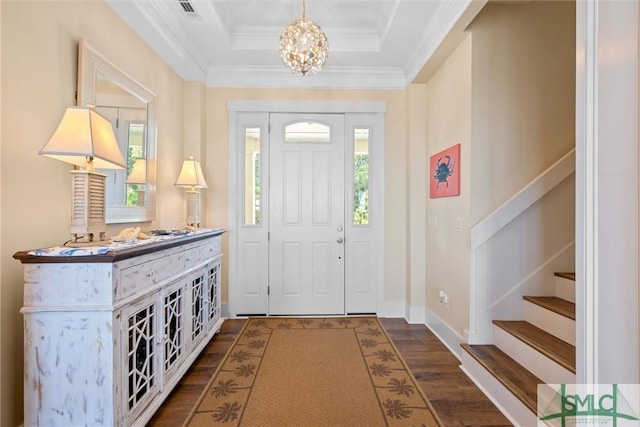 foyer entrance featuring a tray ceiling, a notable chandelier, crown molding, and dark hardwood / wood-style floors