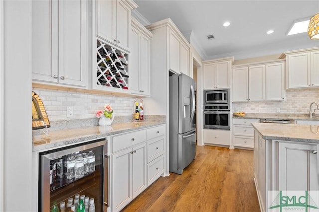 kitchen featuring backsplash, stainless steel appliances, wine cooler, light stone counters, and light wood-type flooring