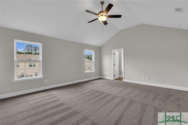 carpeted empty room with lofted ceiling, a ceiling fan, baseboards, and a wealth of natural light