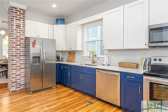 kitchen featuring blue cabinetry, sink, white cabinetry, and stainless steel appliances