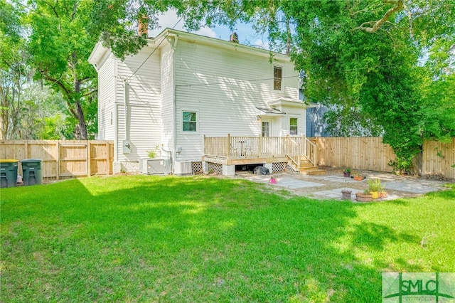 back of property featuring a lawn, a wooden deck, and central AC