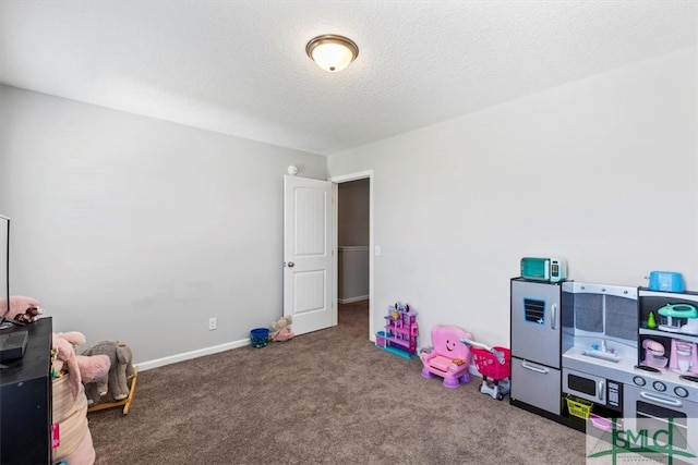 playroom with dark colored carpet and a textured ceiling