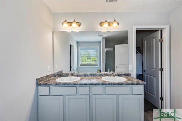 bathroom with dual bowl vanity and tile flooring