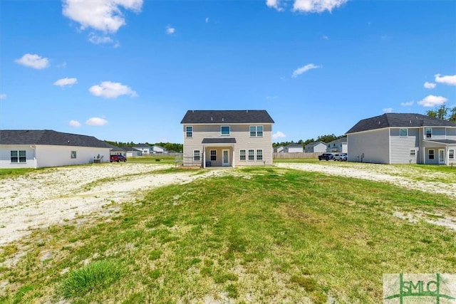 rear view of property featuring a lawn