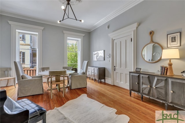 living area with a notable chandelier, wood-type flooring, and crown molding