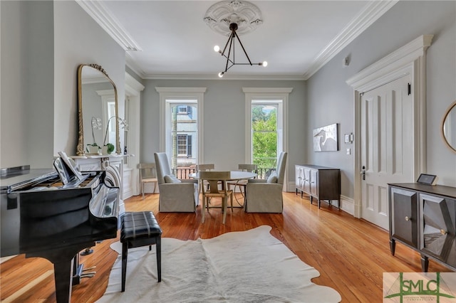 living area featuring an inviting chandelier, light hardwood / wood-style floors, and crown molding