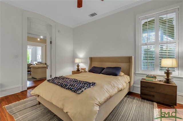 bedroom featuring ceiling fan, ornamental molding, and hardwood / wood-style floors