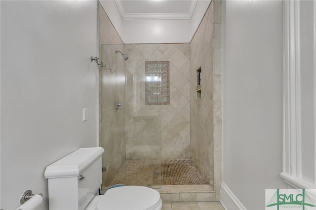 bathroom featuring toilet, a tile shower, crown molding, and tile patterned floors